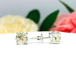A pair of silver basket stud earrings set with light yellow old european cut round cubic zirconias.