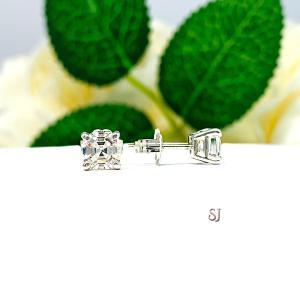 A pair of silver stud earrings with very light tint or "near colorless" asscher cut cubic zirconias. The soft prong basket earrings are on a white surface with the letters 'SJ' in pink text below the earrings.