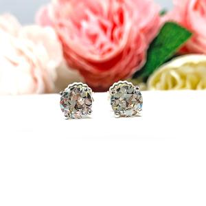A pair of sterling silver four prong basket stud earrings with 'near colorless' or 'G color' old European cut cubic zirconias. The earrings are on a white background with both earrings facing forward to showcase the 'chunky' facets.
