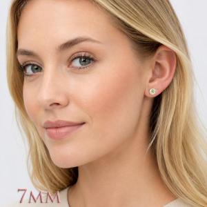 A woman wearing a pair of silver basket stud earrings set with 7mm light yellow old european cut round cubic zirconias.