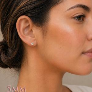 A woman wearing 3-prong martini 5mm round cubic zirconia stud earrings. Model image for size and styling reference — not a photo of the actual earrings.