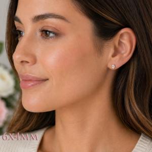 A woman wearing 6x4mm oval cz gold stud earrings. Model image for size and styling reference — not a photo of the actual earrings.