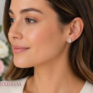 A woman wearing 8x6mm oval cz gold stud earrings. Model image for size and styling reference — not a photo of the actual earrings.