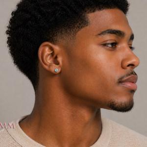 Man wearing sterling silver stud earrings featuring 5mm round authentic blue moissanite stones in basket martini-style settings. Model image for size and styling reference — not a photo of the actual earrings.