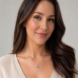 A sterling silver necklace with a 9mm round, light blue moissanite pendant. The pendant is suspended from a delicate silver snake chain. Model image for size and styling reference — not a photo of the actual necklace.