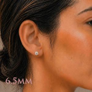 A woman wearing 3-prong martini 6.5mm round cubic zirconia stud earrings. Model image for size and styling reference — not a photo of the actual earrings.