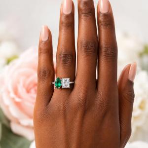 10x5mm marquise lab emerald and 8x6mm radiant‑cut CZ toi et moi ring in sterling silver shown worn on the hand of a woman. Model image for size and styling reference — not a photo of the actual ring.