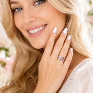 8x5mm colorless pear-cut CZ and an 8x6mm morganite pink color oval‑cut CZ toi et moi ring in sterling silver shown worn on the hand of a woman. Model image for size and styling reference — not a photo of the actual ring.