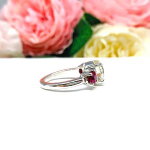 A sterling silver 3-stone ring with a 9mm near colorless round brilliant cut cubic zirconia center that radiates icy sparkle, flanked by two 5mm round deep red lab-created rubies.