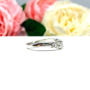 Sterling silver 5-stone curved wedding band featuring 3mm round precision faceted moissanite stones in prong settings, displayed against a soft floral background.