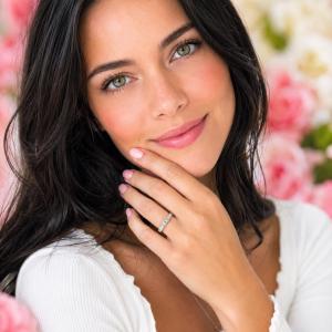A woman wearing a 5-stone wedding band featuring 3mm round moissanites.  Model image for size and styling reference — not a photo of the actual ring.