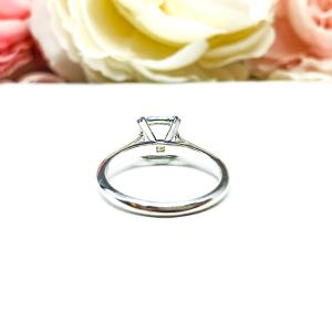 Sterling silver split-prong ring featuring a 7mm cushion-cut light blue aquamarine gemstone. Displayed against a soft-focus floral background, the ring sparkles with contrast and elegance.