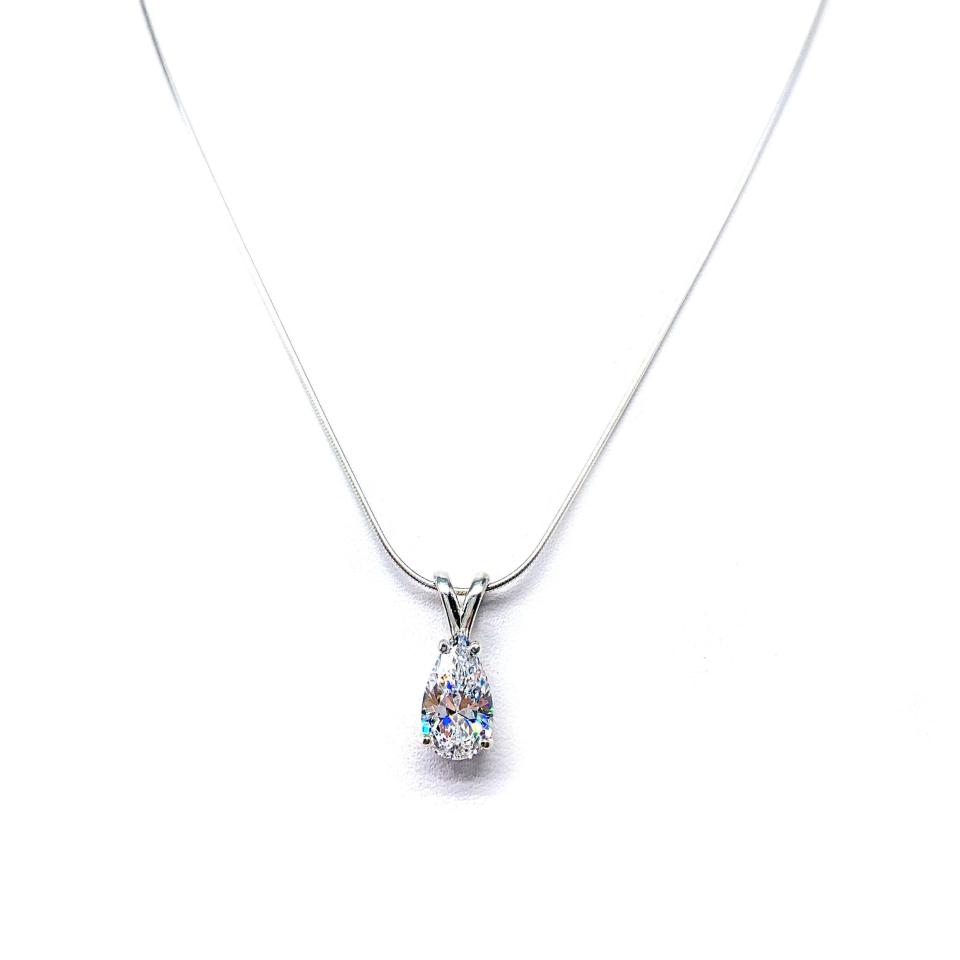 Sterling silver necklace featuring a faceted pear-cut cubic zirconia pendant in a minimalist setting, available in five sizes and shown on a sterling silver chain.