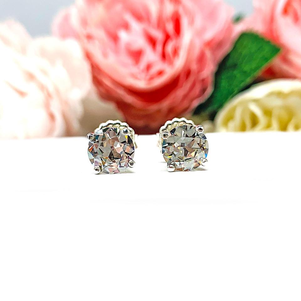 A pair of sterling silver four prong basket stud earrings with 'near colorless' or 'G color' old European cut cubic zirconias. The earrings are on a white background with both earrings facing forward to showcase the 'chunky' facets.
