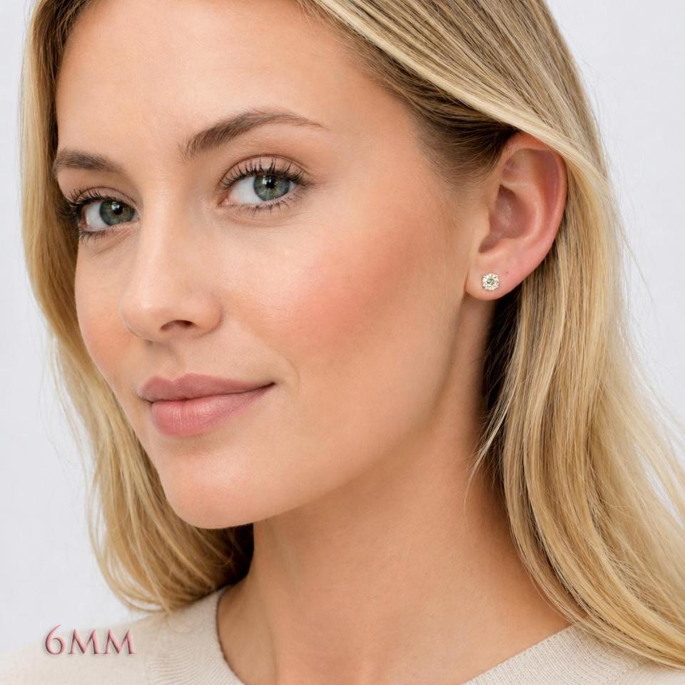 A woman wearing a pair of silver basket stud earrings set with 6mm light yellow old european cut round cubic zirconias.