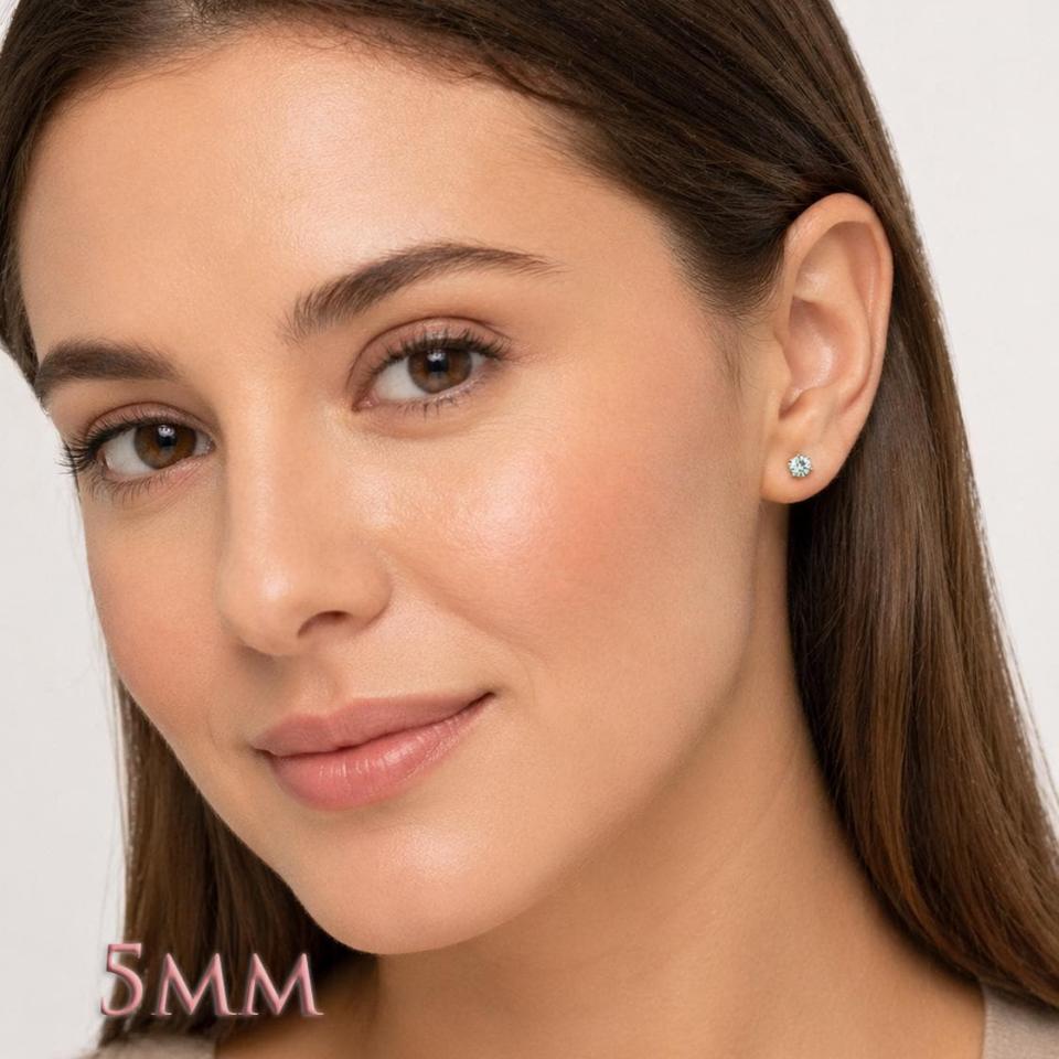 Woman wearing 5mm round blue moissanite martini stud earrings. Model image for size and styling reference — not a photo of the actual earrings.