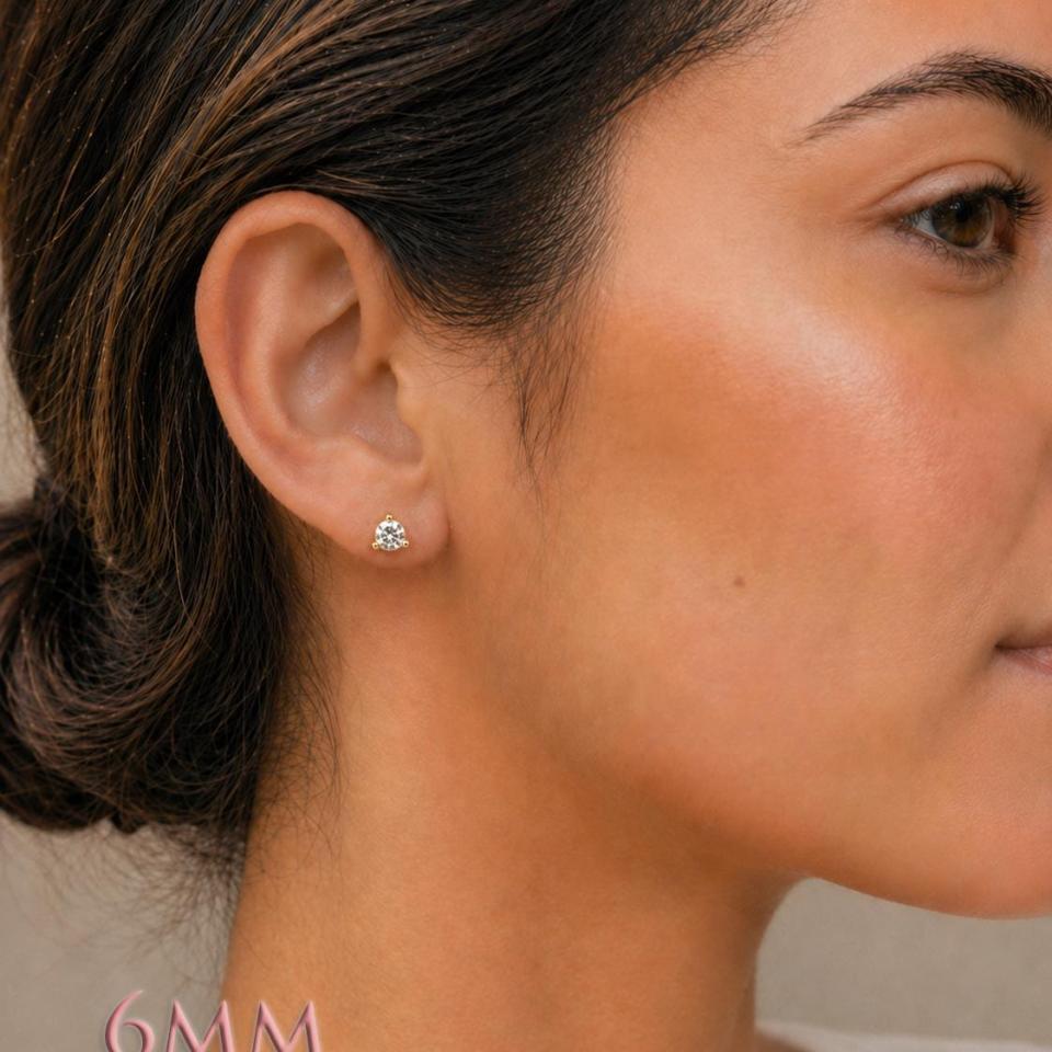 A woman wearing 3-prong martini 6mm round cubic zirconia stud earrings. Model image for size and styling reference — not a photo of the actual earrings.