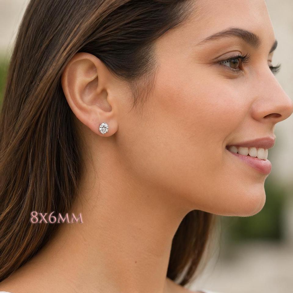 A woman wearing 8x6mm oval cz 6-prong stud earrings. Model image for size and styling reference — not a photo of the actual earrings.