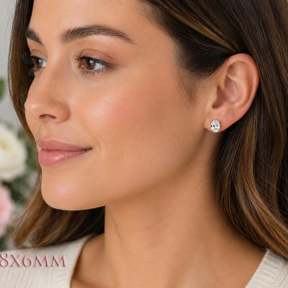 A woman wearing 8x6mm oval cz gold stud earrings. Model image for size and styling reference — not a photo of the actual earrings.