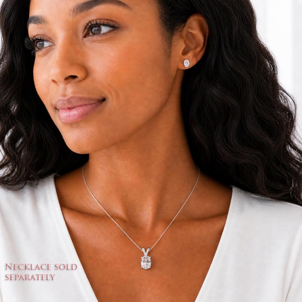 A woman wearing matching oval lab white sapphire stud earrings and pendant necklace. 'NECKLACE SOLD SEPARATELY' appears in pink text in the image. Model image for size and styling reference — not a photo of the actual necklace.