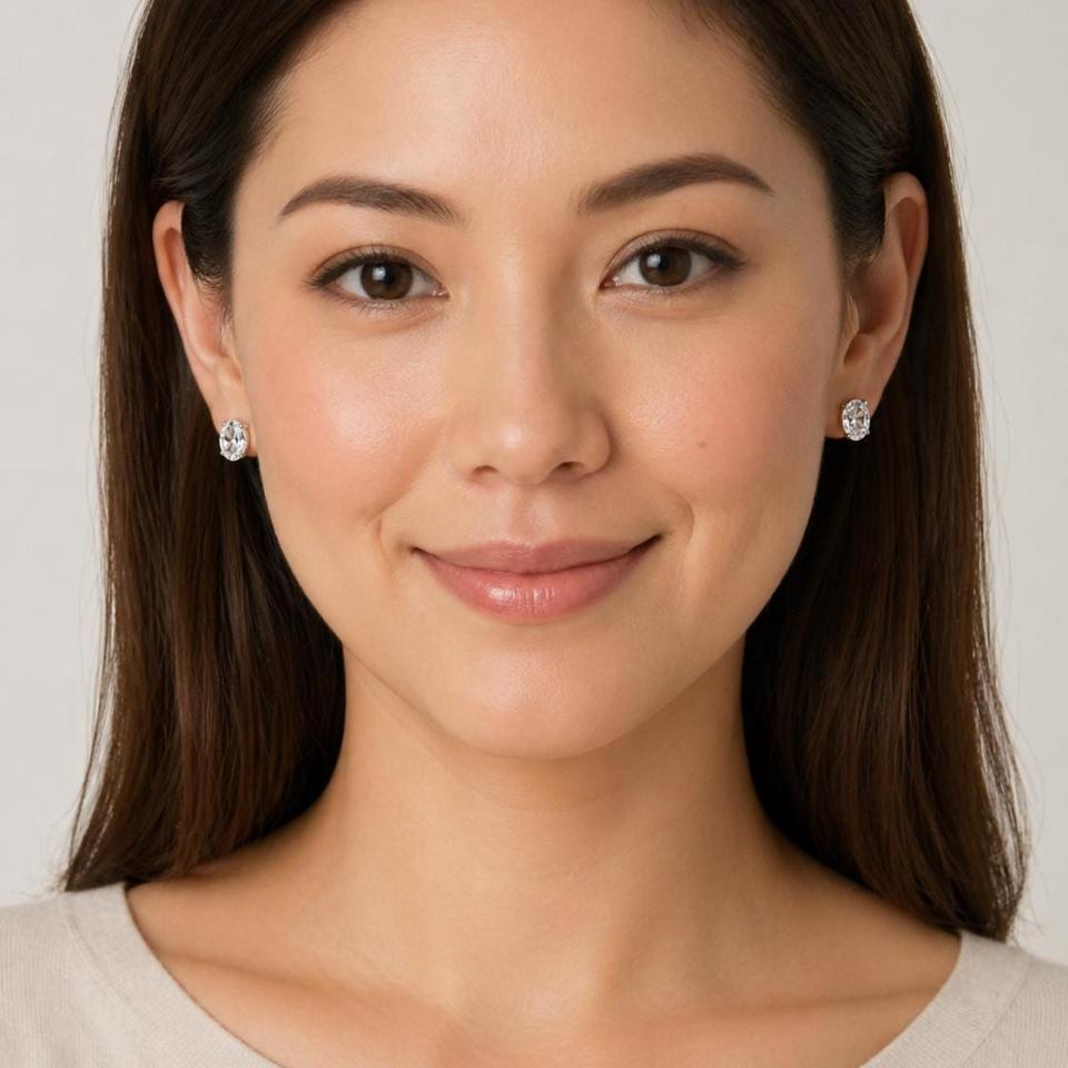 A man wearing 9x7mm oval white topaz stud earrings. Model image for size and styling reference — not a photo of the actual earrings.
