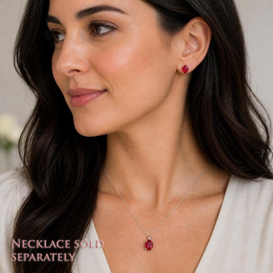 A woman wearing oval lab ruby sterling silver pendant necklace and matching earrings. 'NECKLACE SOLD SEPARATELY' appears in pink text in the image.  Model image for size and styling reference — not a photo of the actual necklace.