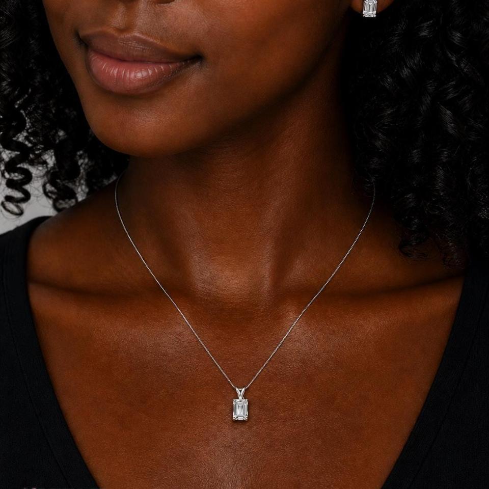 A woman wearing matching emerald cut white topaz necklace and earrings. 'NECKLACE SOLD SEPARATELY' appears in pink text in the image.