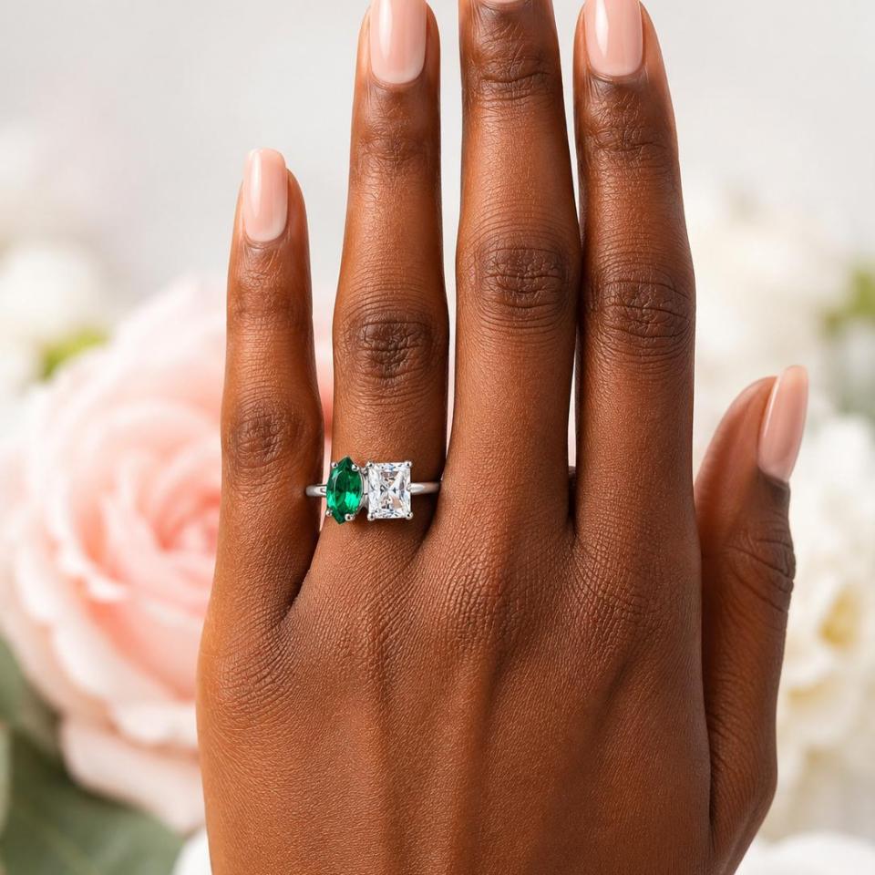 10x5mm marquise lab emerald and 8x6mm radiant‑cut CZ toi et moi ring in sterling silver shown worn on the hand of a woman. Model image for size and styling reference — not a photo of the actual ring.