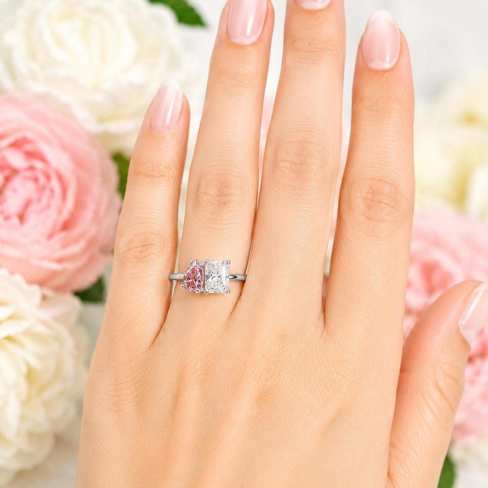 8x5mm morganite pink color pear CZ and 8x6mm colorless radiant-cut cz toi et moi ring in sterling silver shown worn on the hand of a woman. Model image for size and styling reference — not a photo of the actual ring.