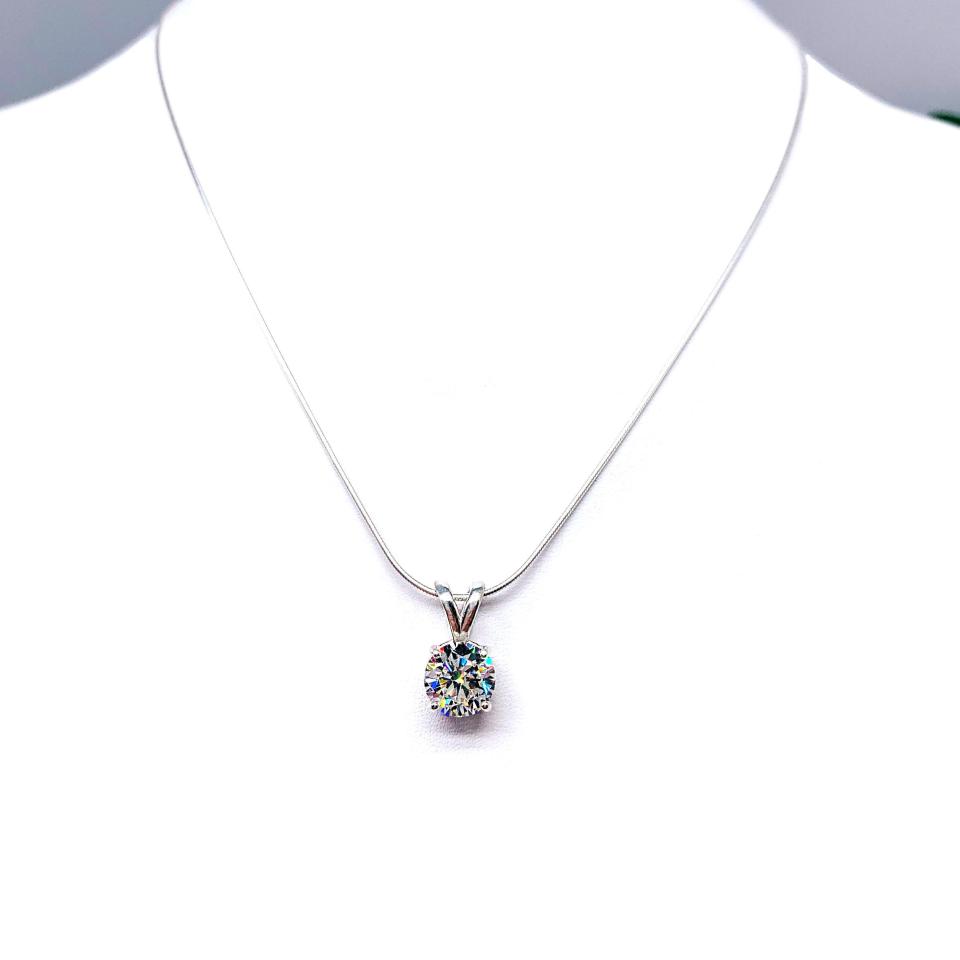 Sterling silver necklace with round-cut near colorless cubic zirconia pendant in a 4-prong basket setting with a lotus flower design.