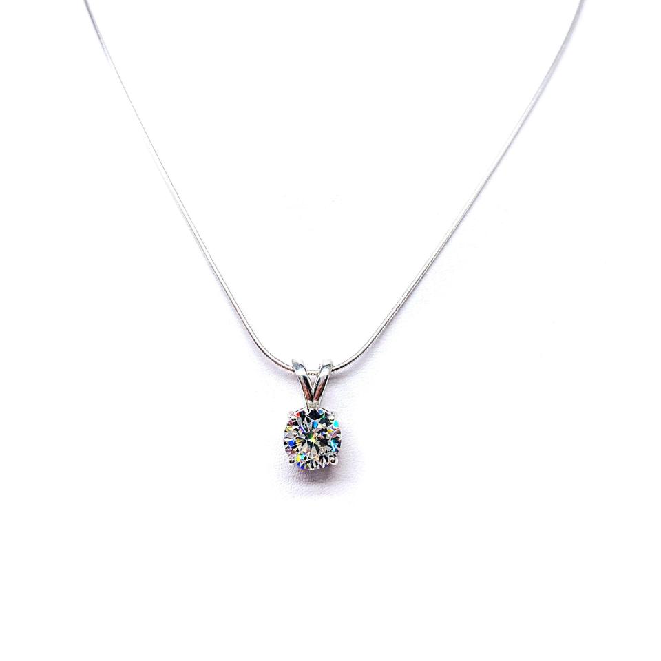 Sterling silver necklace with round-cut near colorless cubic zirconia pendant in a 4-prong basket setting with a lotus flower design.
