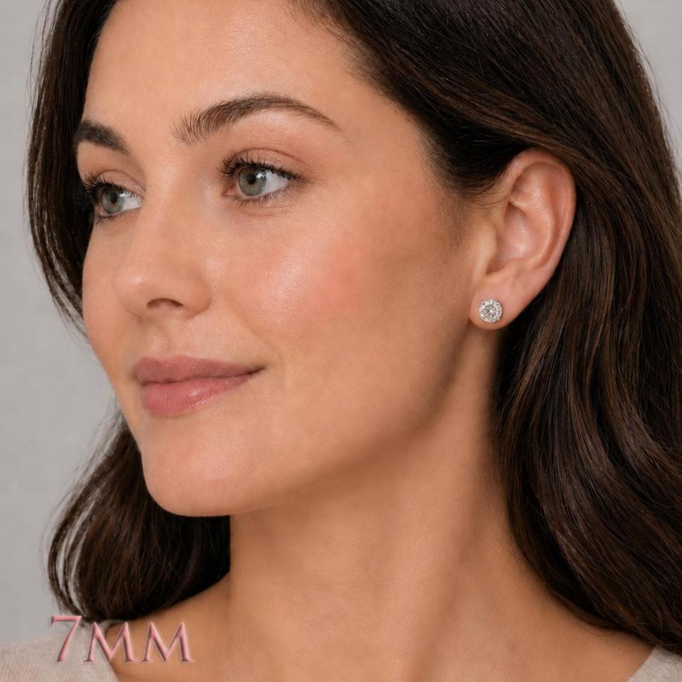 A woman wearing 7mm mixed-brilliant round-cut lab white sapphire sterling silver stud earrings. Model image for size and styling reference — not a photo of the actual earrings.