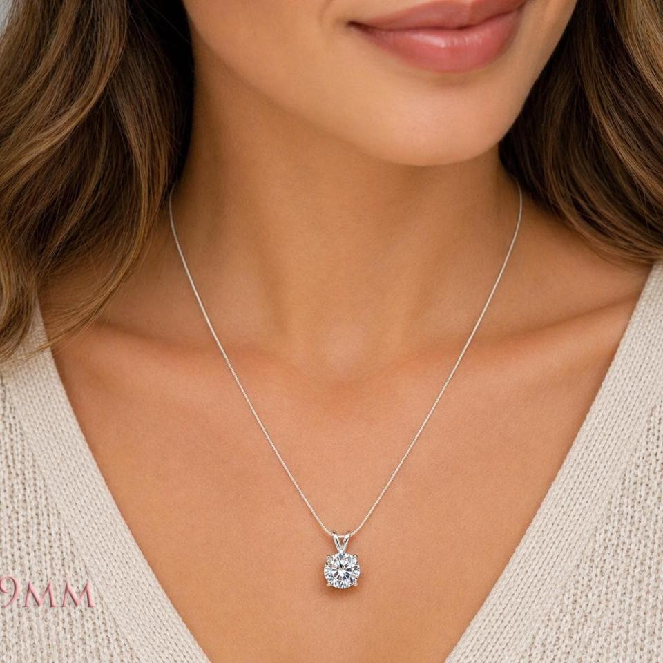 A woman wearing an 9mm round lab white sapphire sterling silver pendant necklace. Model image for size and styling reference — not a photo of the actual necklace.