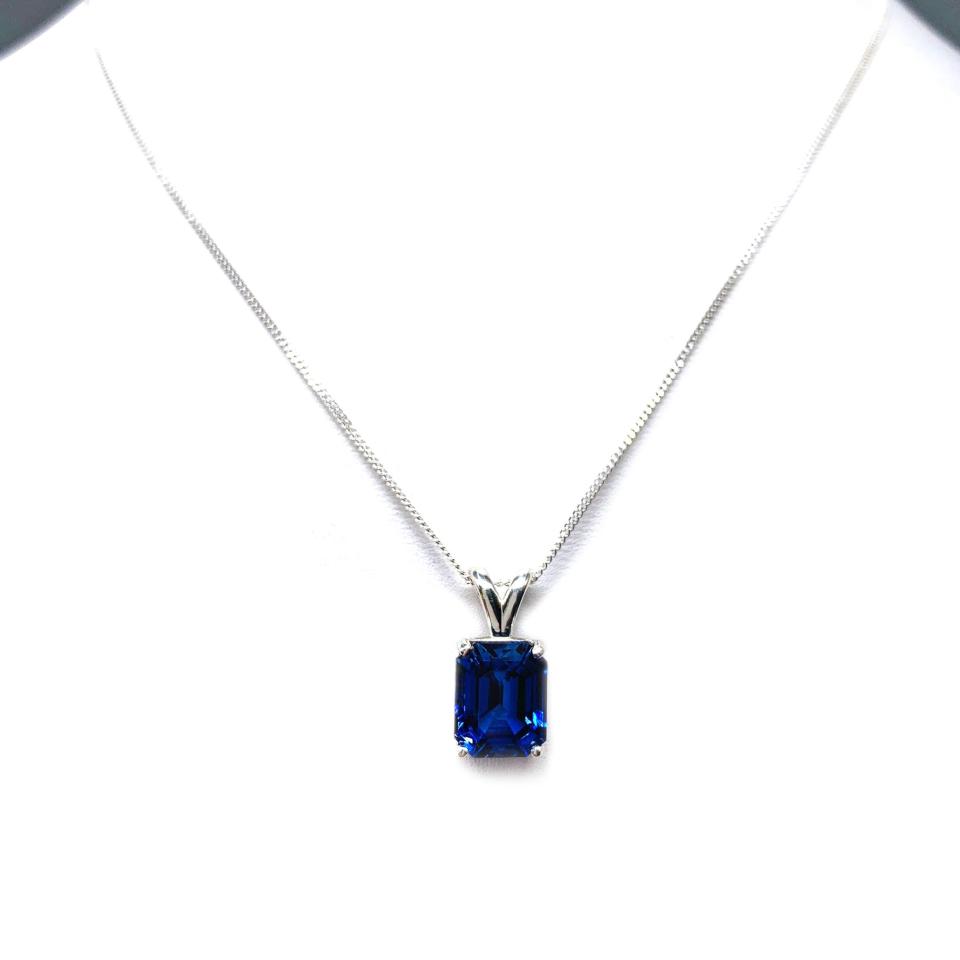 Sterling silver necklace featuring a 10x8mm emerald-cut lab-created blue sapphire pendant in a 4-prong setting.