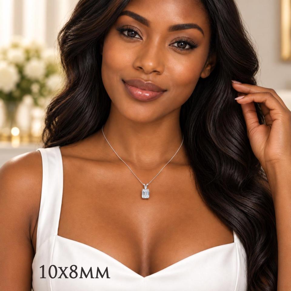 A woman wearing a sterling silver necklace featuring a 10x8mm emerald-cut lab-created white sapphire pendant in a 4-prong setting. Model image for size and styling reference — not a photo of the actual necklace.