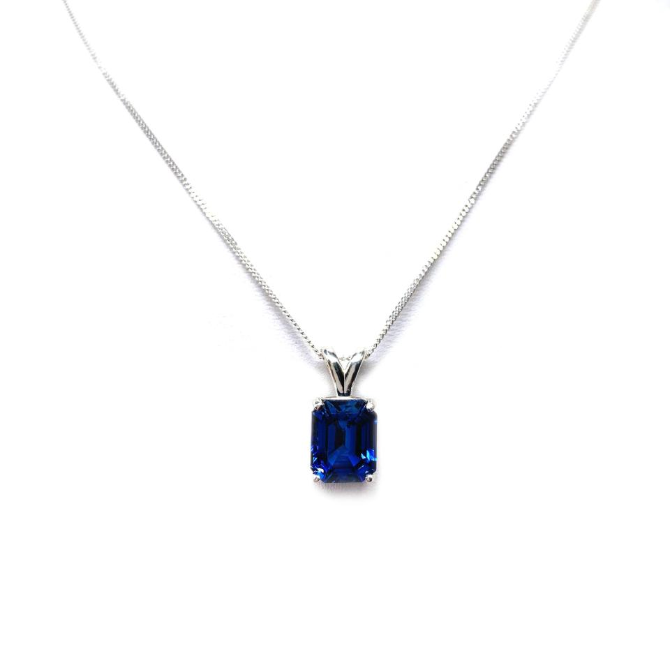 Sterling silver necklace featuring a 10x8mm emerald-cut lab-created blue sapphire pendant in a 4-prong setting.