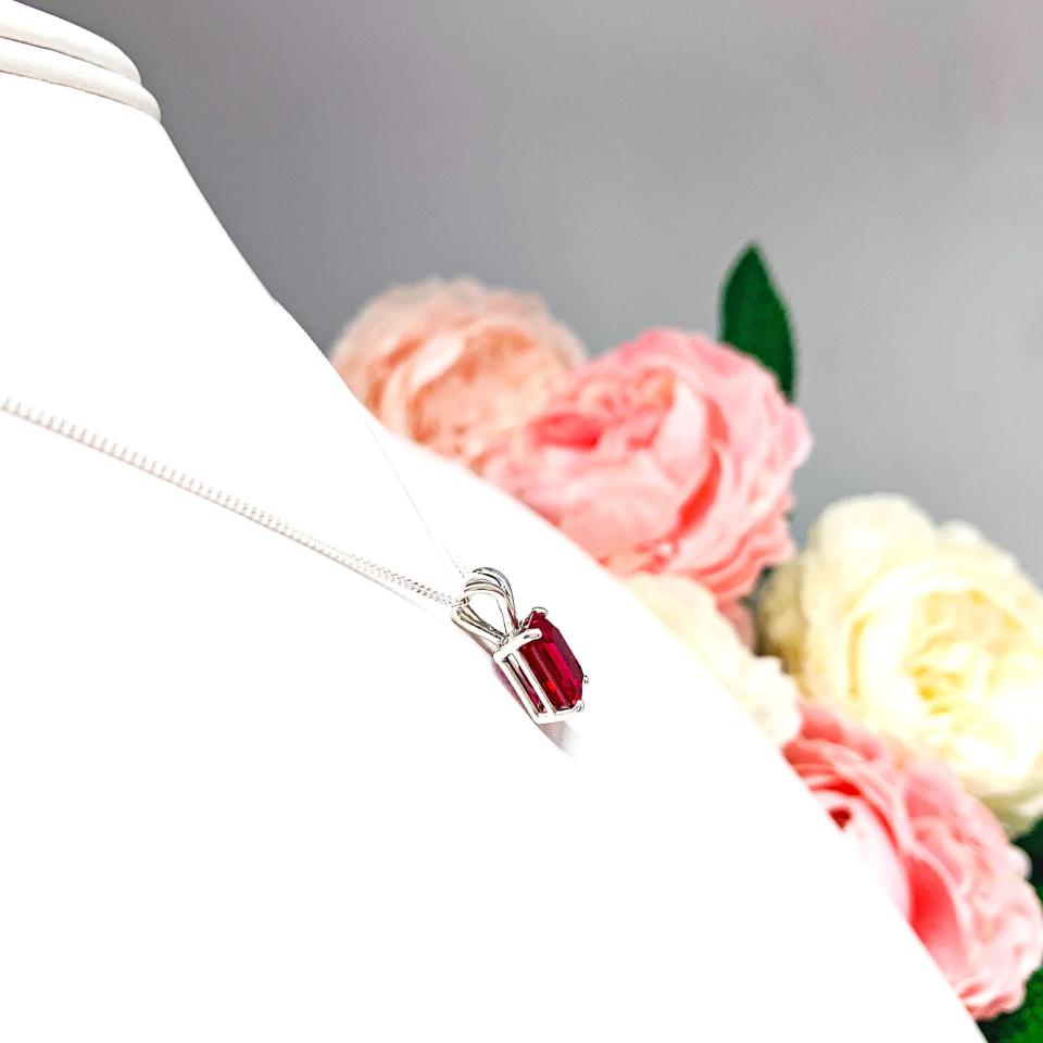 Sterling silver necklace featuring a 9x7mm emerald-cut lab-created ruby pendant in a 4-prong setting.