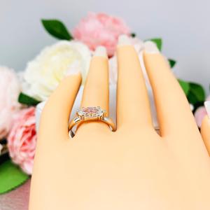 Mannequin hand with long white shimmery nails, displayed against a soft white-gray background with pink and white floral accents. The hand is wearing a 6-prong sterling silver, horizontal east west set engagement ring featuring a precision-faceted near colorless (G/H color) marquise cubic zirconia.