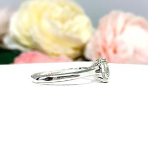 Close-up of a sterling silver cathedral-style engagement ring featuring an 8mm near colorless cushion cut cubic zirconia center stone. The ring is shown facing forward, showcasing the brilliant faceting of the center stone and split prongs.