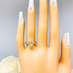 Mannequin hand with long white shimmery nails, displayed against a soft white-gray background with pink and white floral accents. The hand is wearing a sterling silver split prong cathedral engagement ring set with an 8mm light yellow old mine cut cubic zirconia.