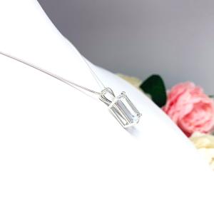 Close-up of an emerald-cut white topaz pendant necklace featuring a faceted natural gemstone in a sterling silver prong setting, suspended from a delicate sterling chain. Available in four stone sizes.