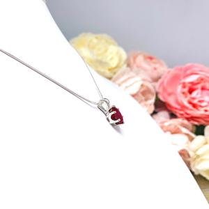 Sterling silver necklace featuring an oval lab-created ruby pendant in a six-prong setting, suspended from a thin silver chain and photographed against a white background.