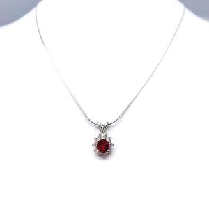 Sterling silver halo pendant necklace featuring a round vivid deep red lab ruby center stone (5mm–8mm), surrounded by small CZs in a floral-inspired setting on a delicate silver chain.