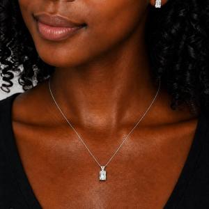 A woman wearing matching emerald cut white topaz sterling silver necklace and earrings. 'EARRINGS SOLD SEPARATELY' appears in pink text in the image. Model image for size and styling reference — not a photo of the actual necklace.