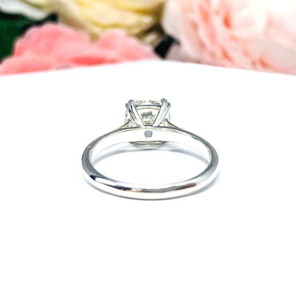 Close-up of a sterling silver cathedral-style engagement ring featuring an 8mm near colorless cushion cut cubic zirconia center stone. The ring is shown facing forward, showcasing the brilliant faceting of the center stone and split prongs.