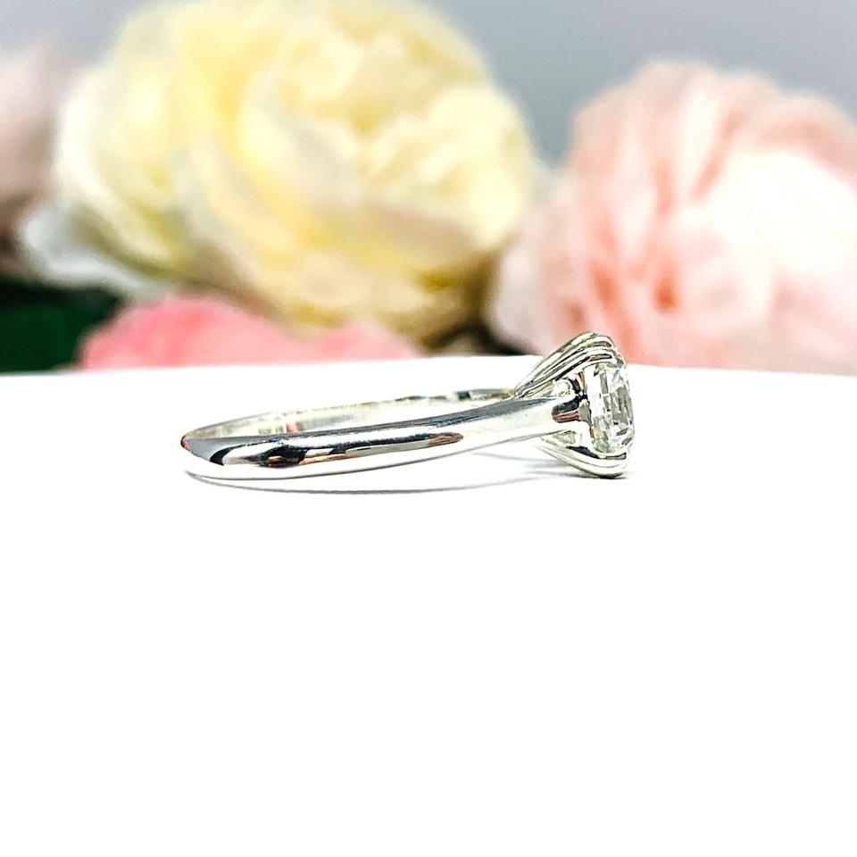 Close-up of a sterling silver cathedral-style engagement ring featuring an 8mm near colorless cushion cut cubic zirconia center stone. The ring is shown facing forward, showcasing the brilliant faceting of the center stone and split prongs.