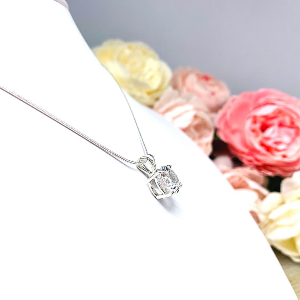 Sterling silver necklace featuring a round lab-created white sapphire pendant in a 4-prong setting, available in five sizes.