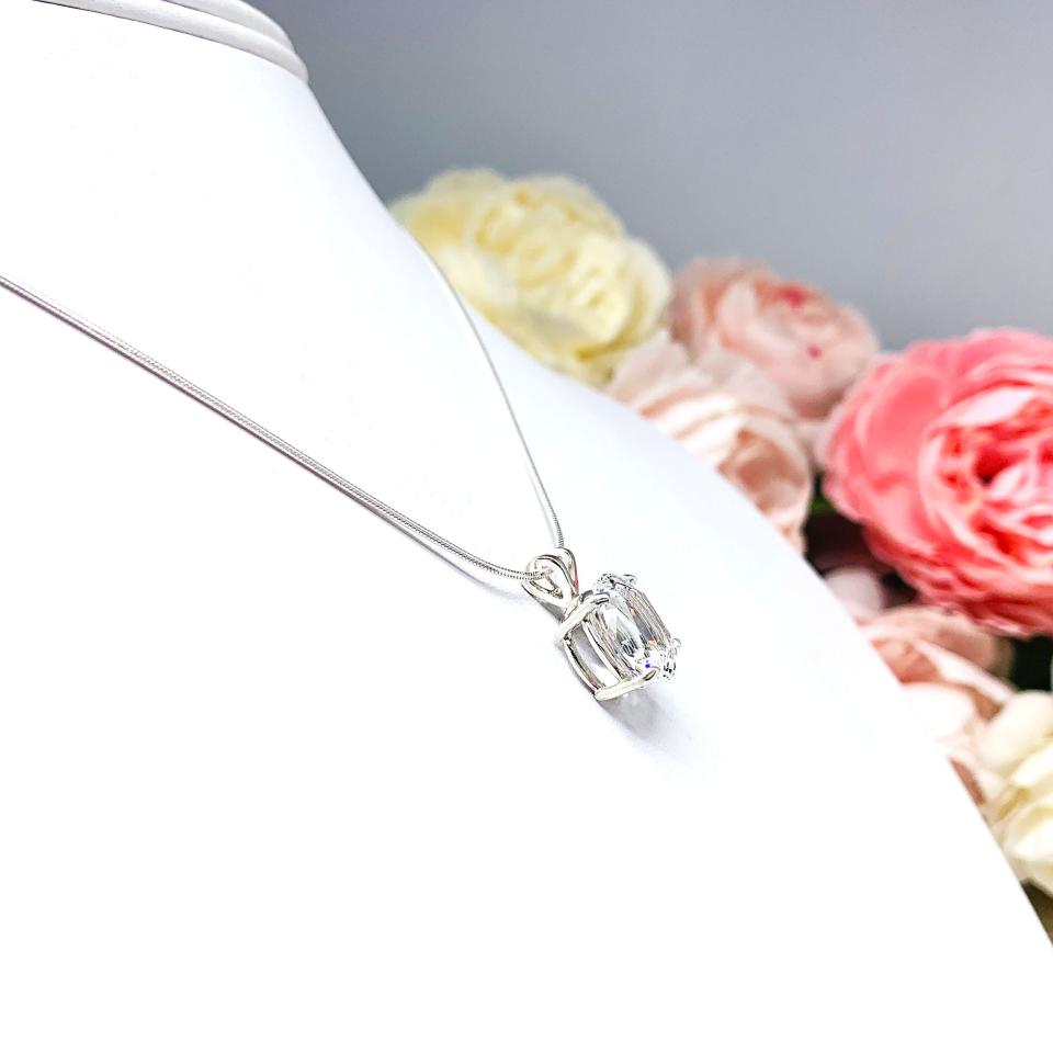 Sterling silver necklace featuring an oval lab-created white sapphire pendant in a 4-prong setting, available in four sizes.