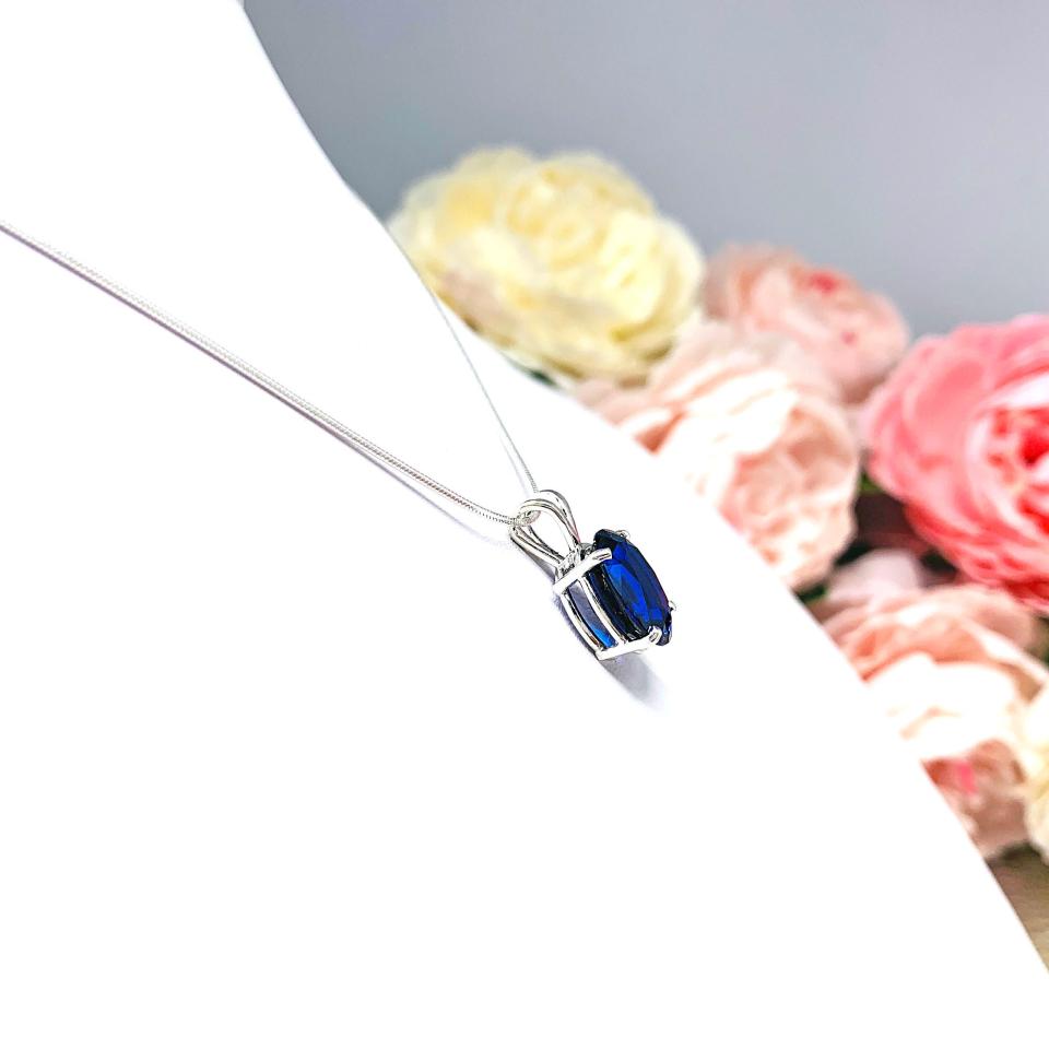 Sterling silver necklace featuring an oval lab-created blue sapphire pendant in a 4-prong setting, available in six sizes.