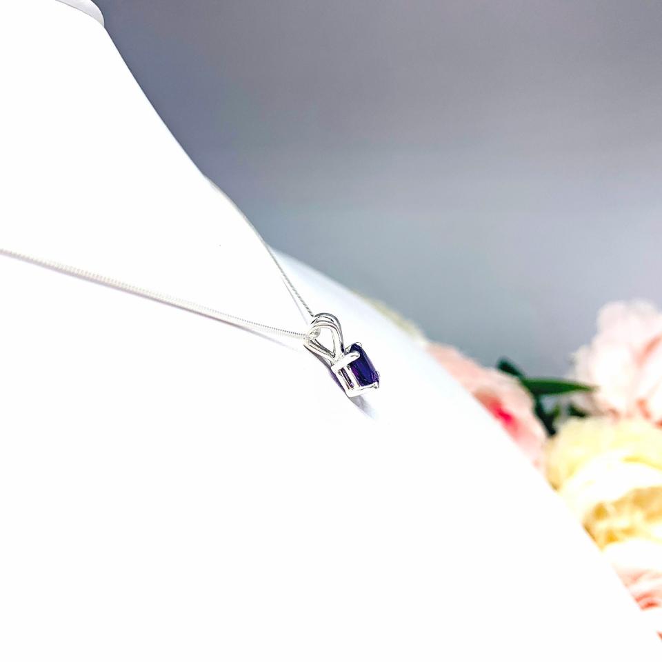 Sterling silver necklace featuring a natural African amethyst pendant in an oval cut, secured by a four-prong setting and displayed on a sterling silver chain.